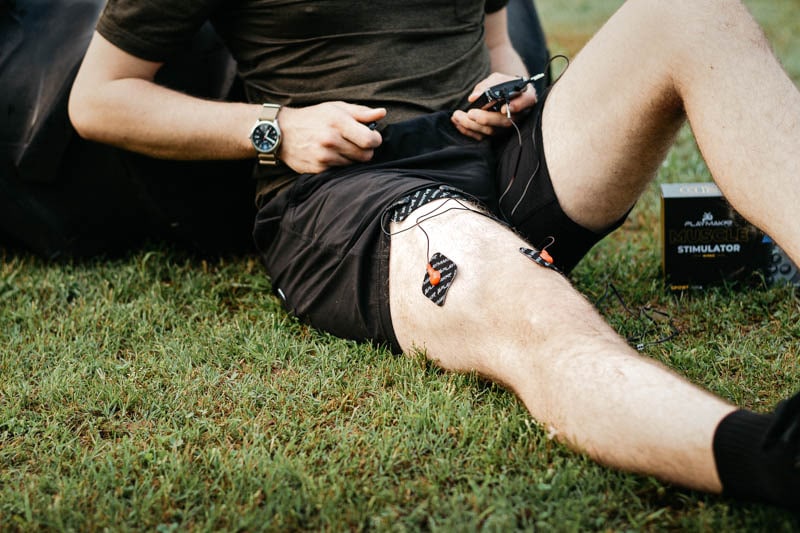 athlete using wired muscle stimulator on quadricep