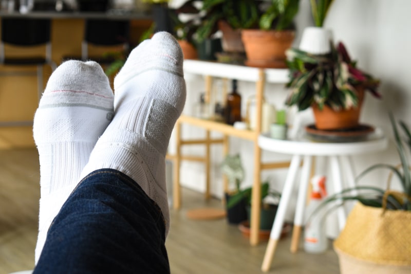 feet up and crossed on table wearing white strideline crew