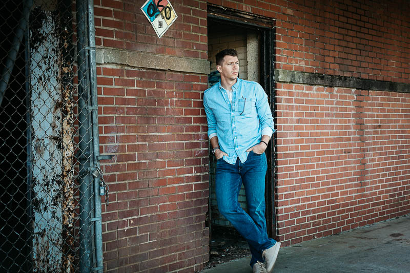 GAP model in denim shirt leaning against wall