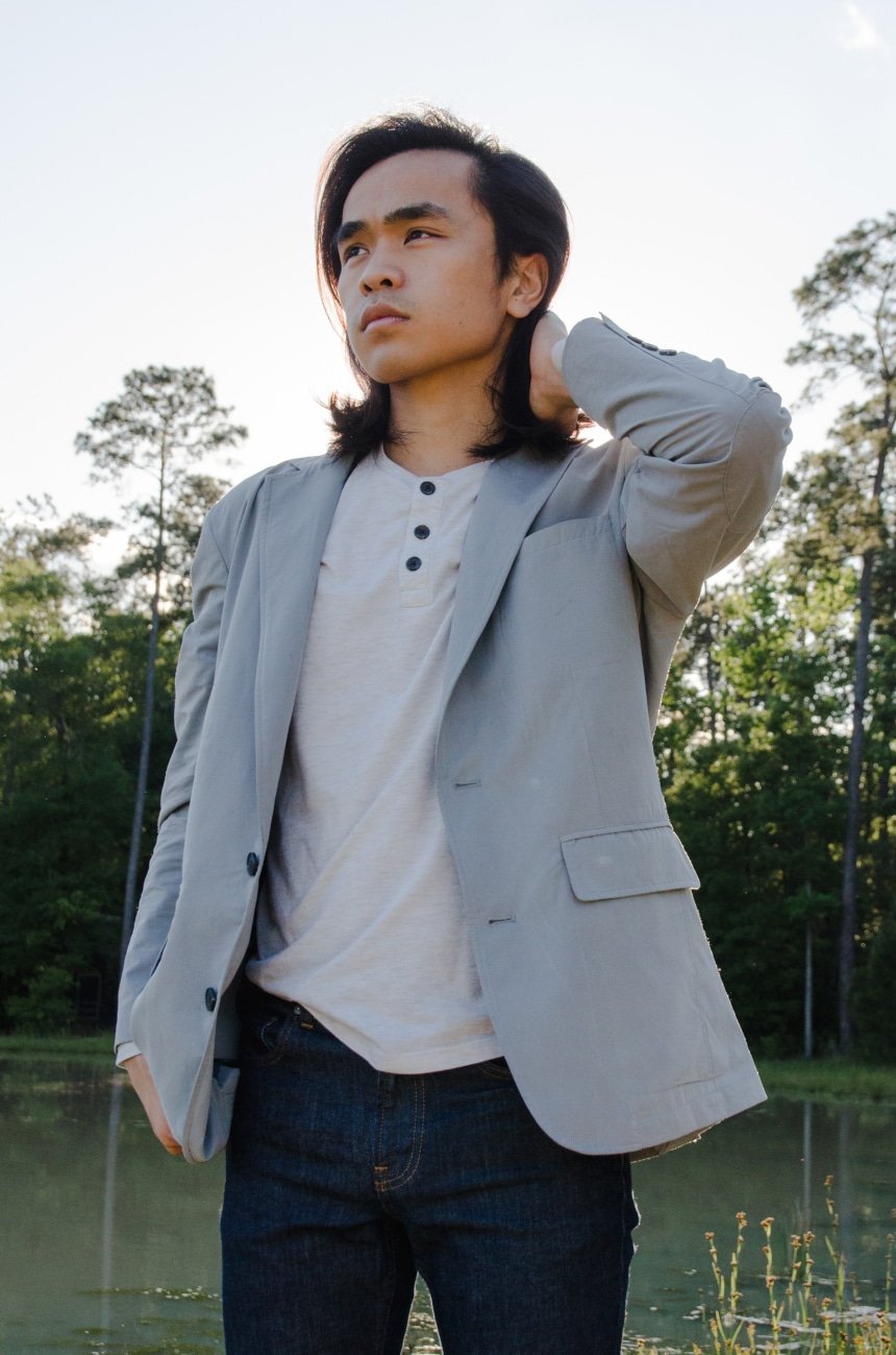 Male model Wearing TravelSmith On The Fly Lightweight Year Round Travel Blazer by Territory Ahead Outside In Park While Looking Into The Distance