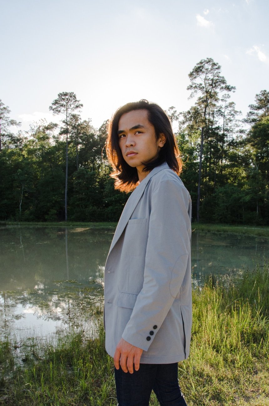 Male model Wearing TravelSmith On The Fly Lightweight Year Round Travel Blazer by Territory Ahead Outside In Park While Looking Over Shoulder