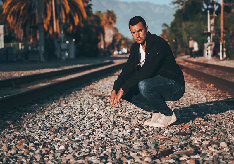 Man crouching in black bomber