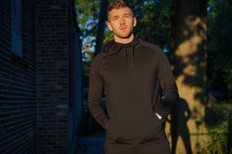 Man in barbell hoodie and pants in sunlight