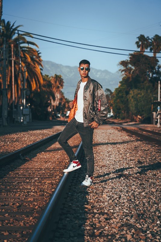 Man in bomber jacket on train tracks