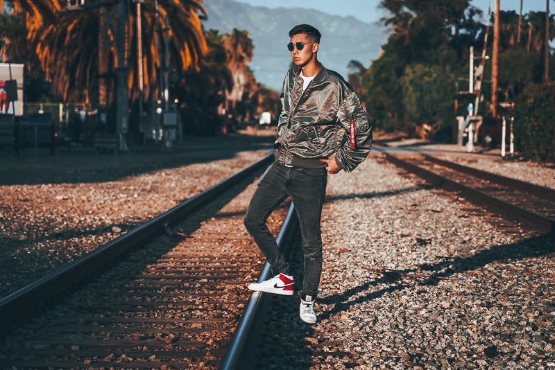 Man in grey bomber jacket on tracks