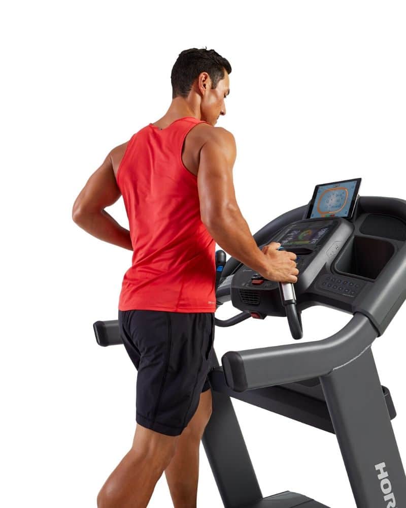 man in red shirt using heart rate feature treadmill