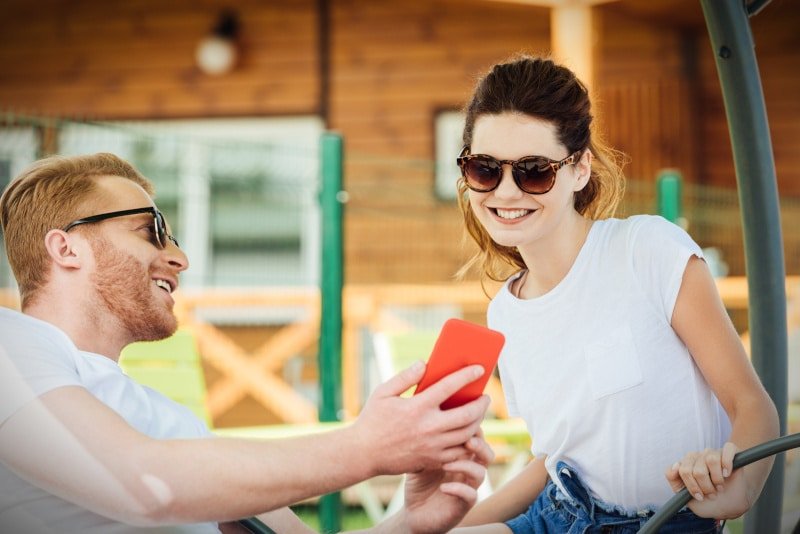 Man showing smart phone to a woman