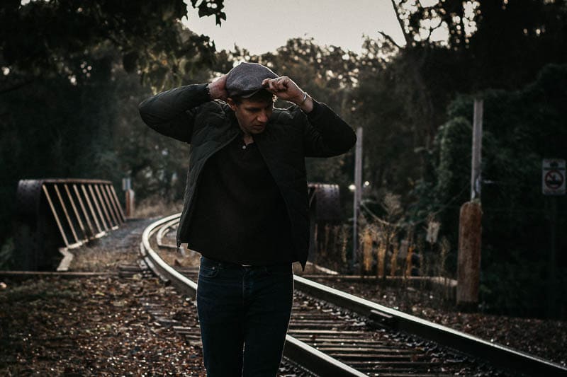 model adjusting hat wearing Frank and Oak style plan outfit