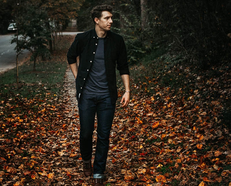 model in black oxford and blue tshirt on red fall leaves