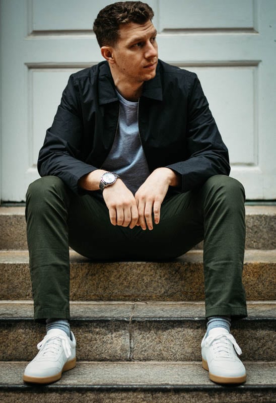 model sitting on concrete step wearing minimalist outfit from asket