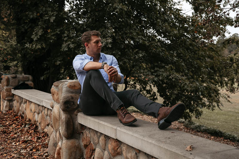 model sitting wearing L Estrange blue oxford and grey chinos