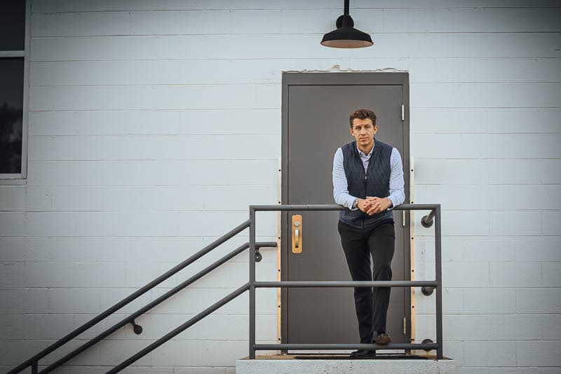 model standing on stairs wearing black chelsea boots and blue vest