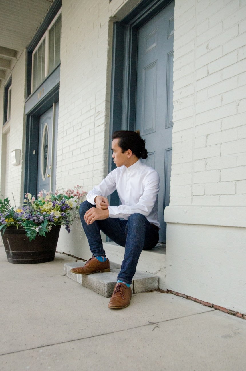 Model Wearing Apposta Coolmax Twill and Sitting On Stoop Wearing Jeans and Boots And Looking In The Distance