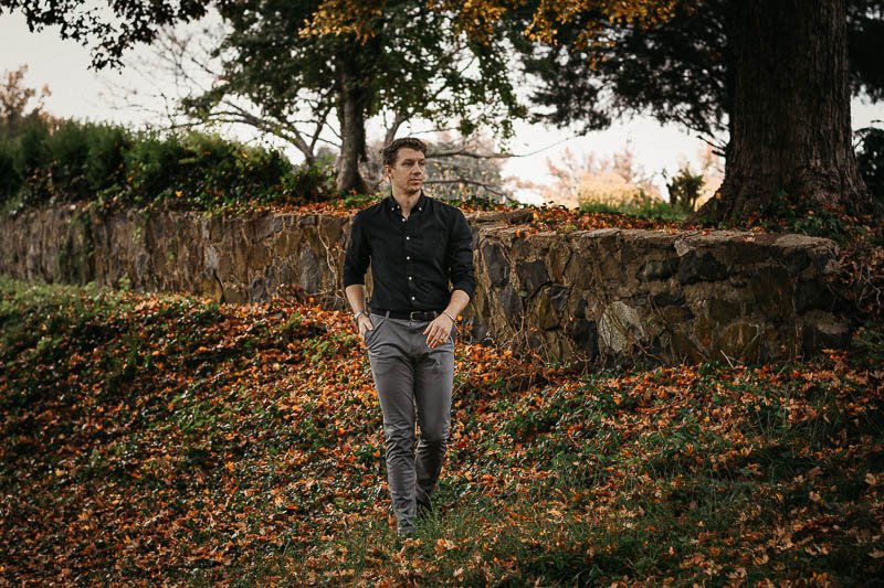 model wearing black tucked in oxford shirt and grey chinos