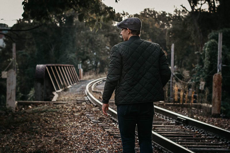 model wearing green bomber jacket quilted with back to camera