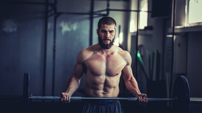 Muscular Model Doing a Barbell Curl