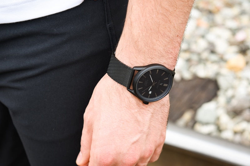 Vincero Kairos black strap black dial on wrist with model wearing jeans